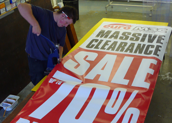 Eyelets being put into a banner